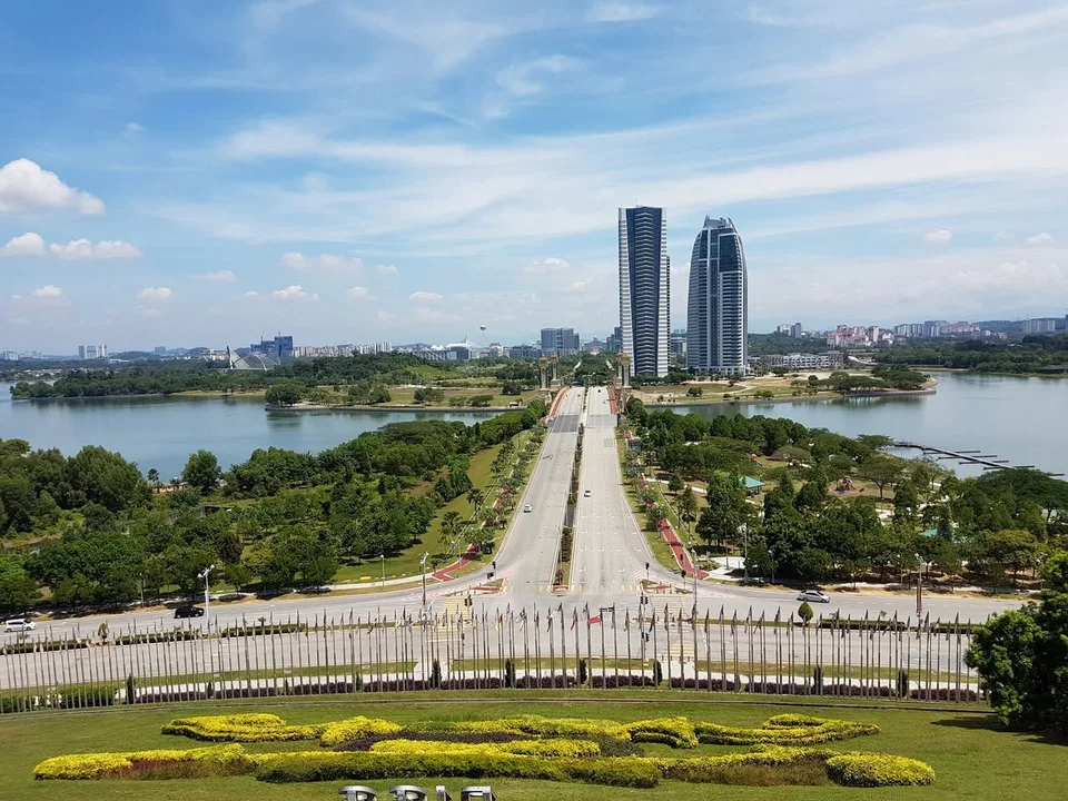 A view from the convention centre grounds looks along the road and Seri Gemilang Bridge, between green banks and water.