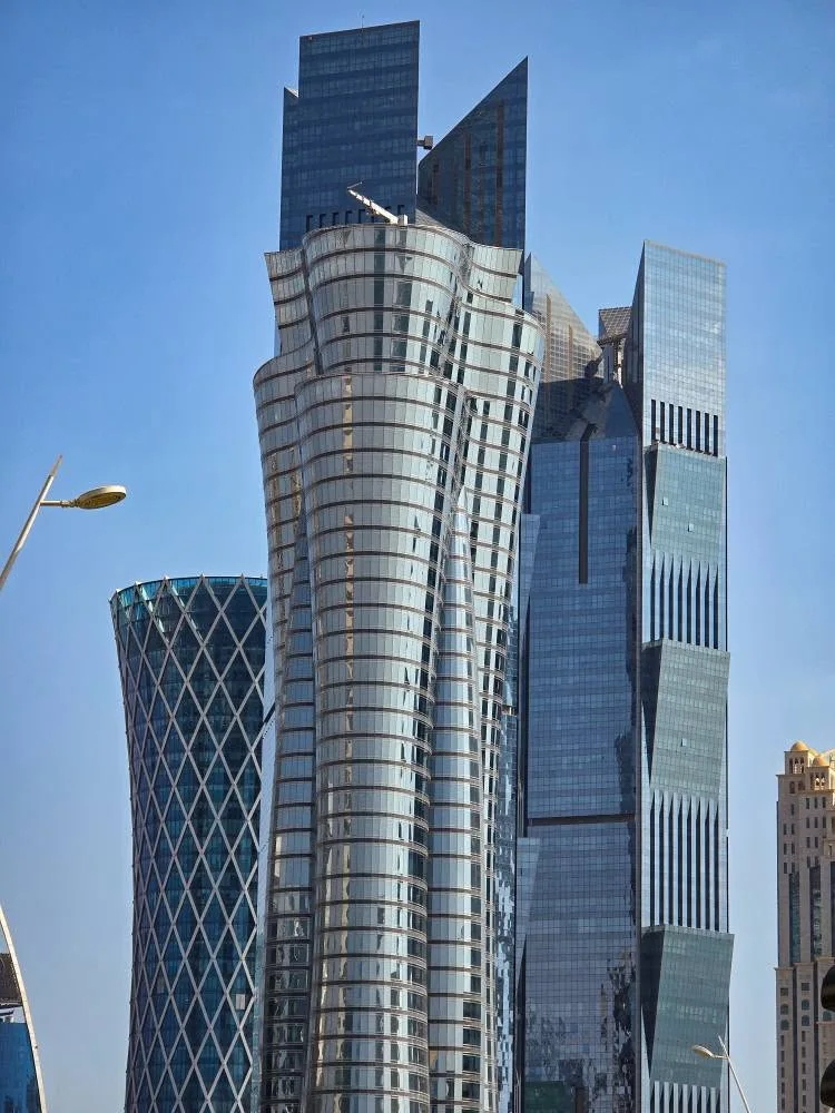 Glass towers rise against a clear blue sky in Doha’s business district.