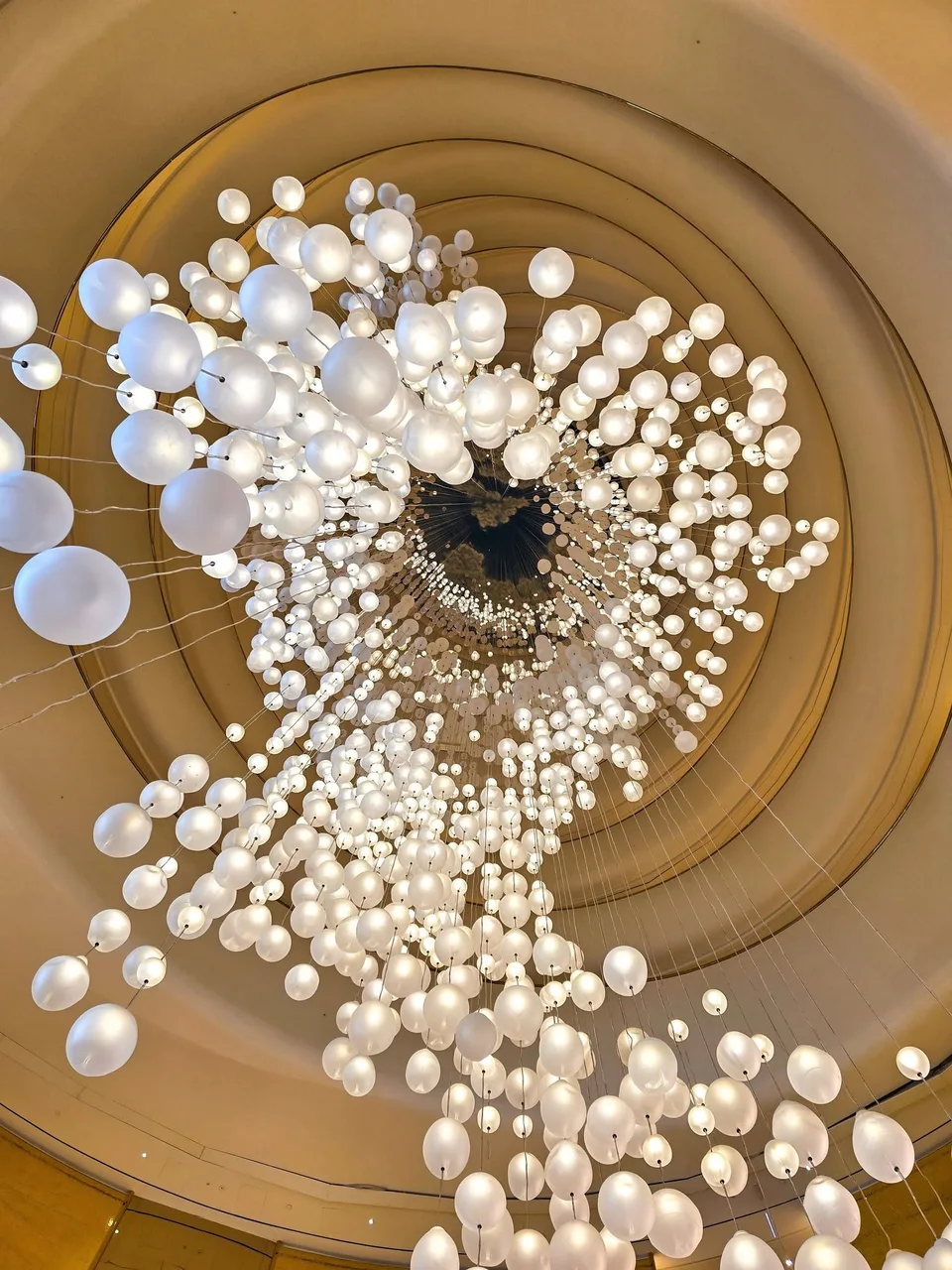White globe lights hang from cables between the curved wings of Katara Towers.