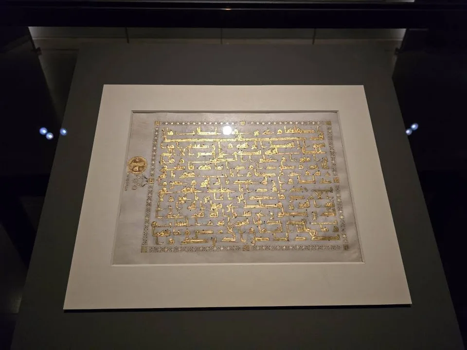 Dense lines of Arabic writing cover a gold-coloured manuscript folio.