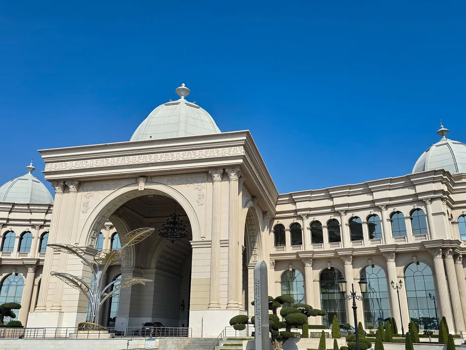 Pale domes and an ornate arched entrance rise above the Place Vendôme shopping façade.