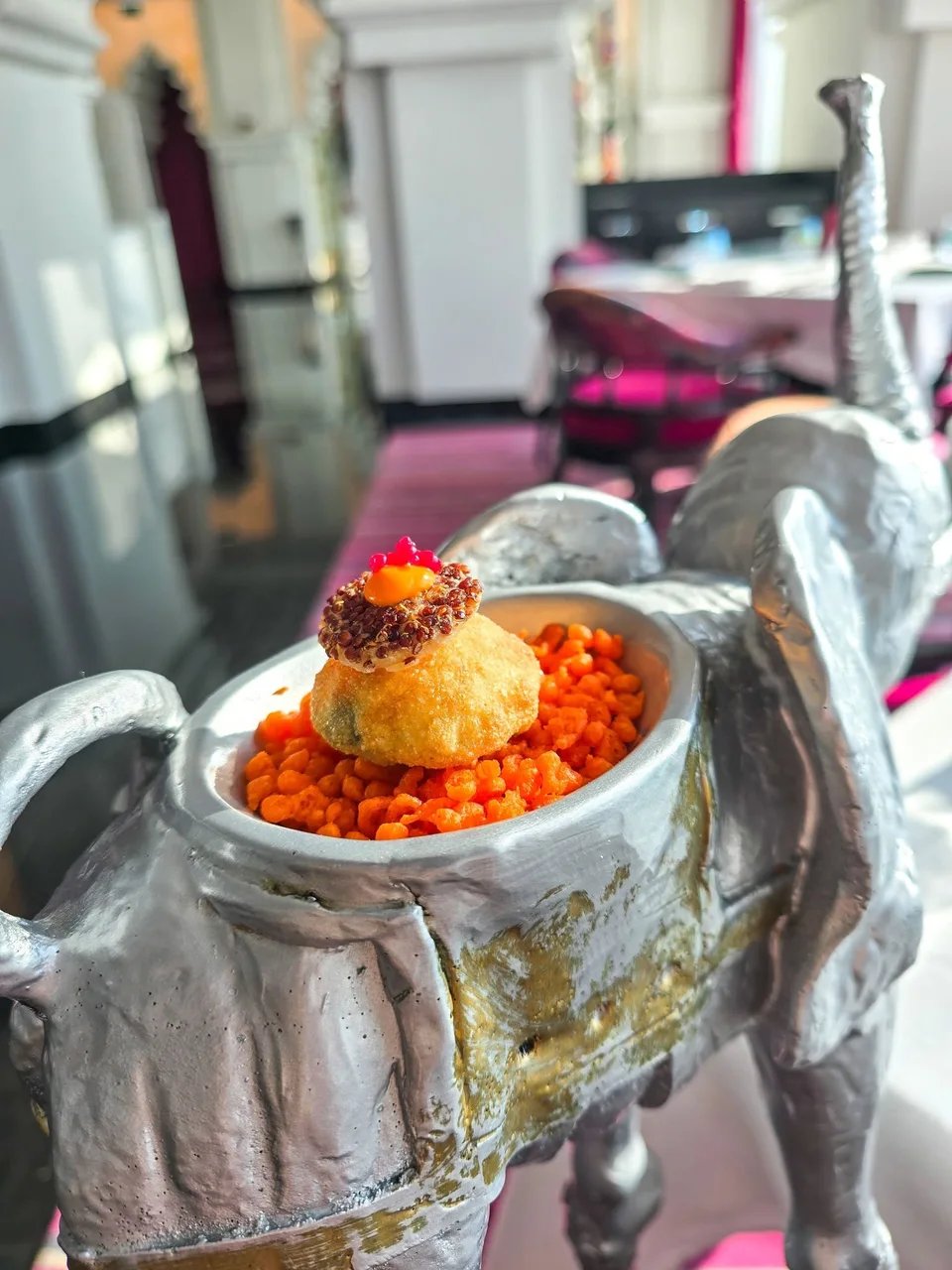 Small bites are arranged on a decorative silver elephant-shaped serving stand.